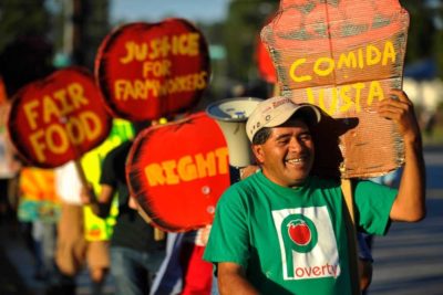 Image included is a photo of Food and Farm Workers at a Rally